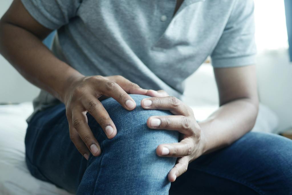 Man holding onto right knee